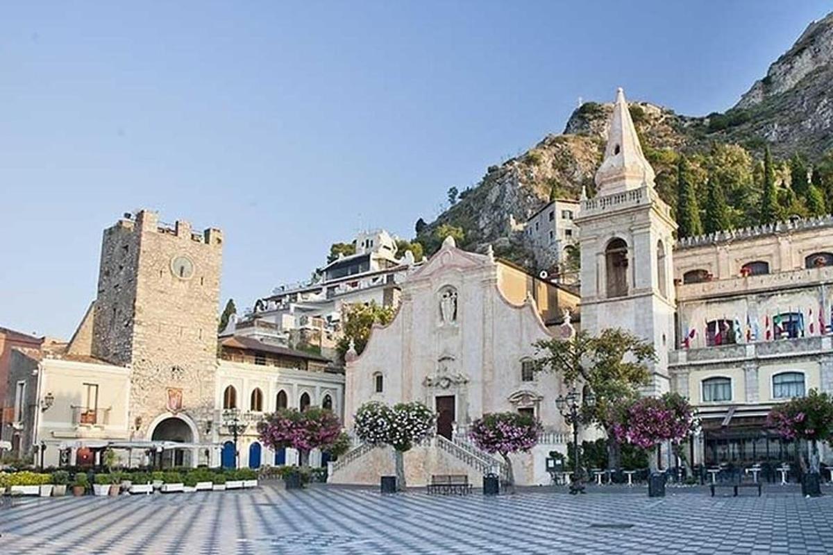 Un gran edificio con una torre de reloj y una montaña.