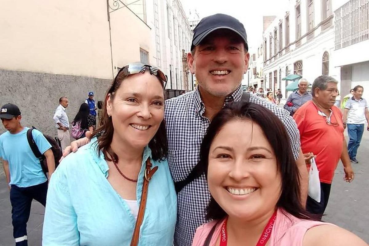 seorang lelaki dan dua wanita berdiri di jalan bandar