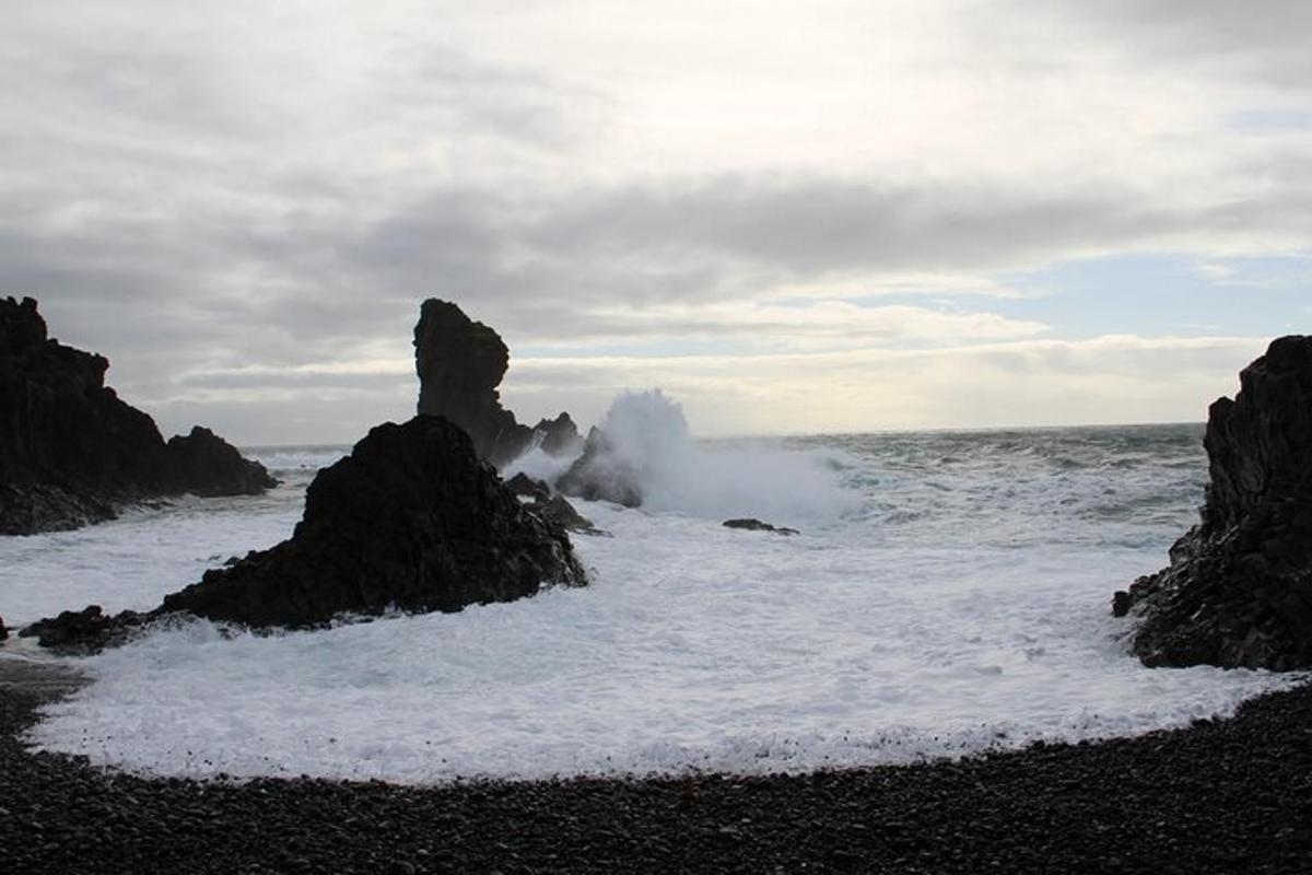 eine Welle, die an einem Strand mit Felsen im Meer bricht