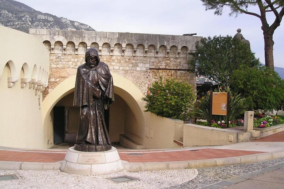 una statua di un uomo in piedi davanti a un edificio