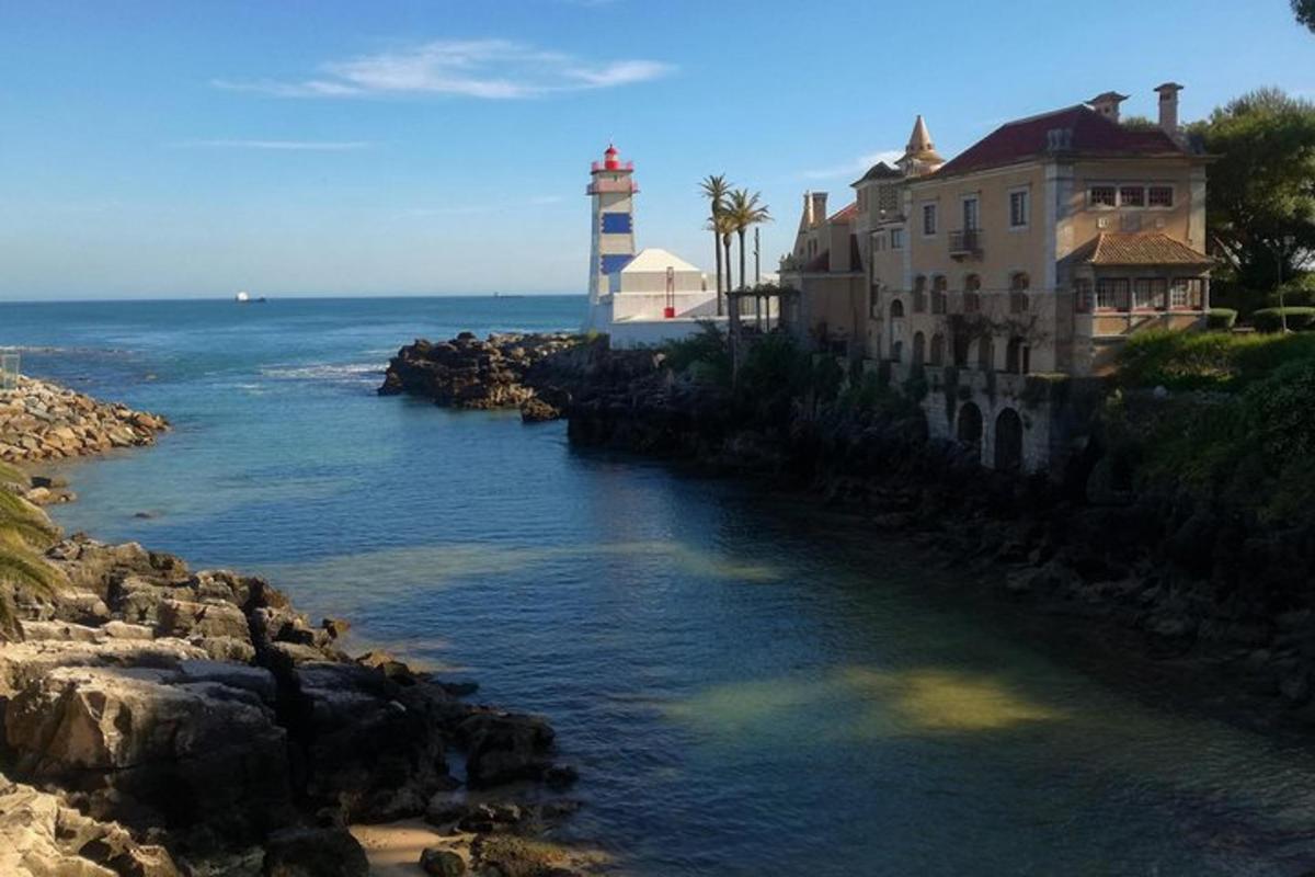 a lighthouse and buildings next to a body of water