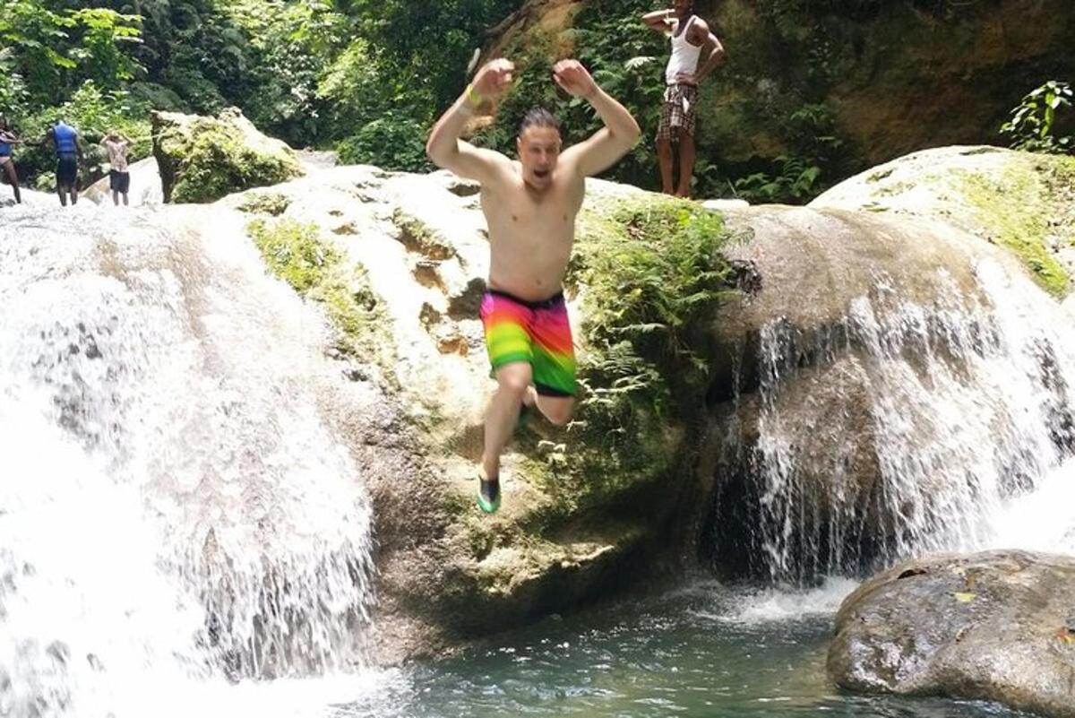 un homme sautant d'une cascade dans une rivière