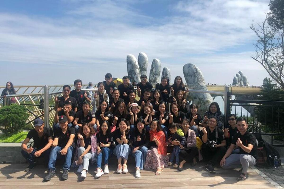 un grup de persones posant per a una foto davant d'una estàtua