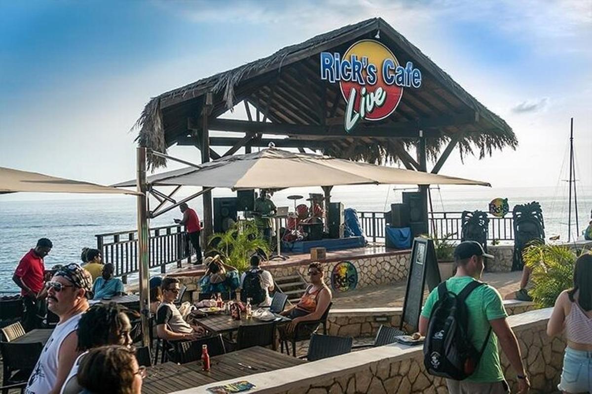 un grup de persones assegudes en un bar a prop de l'oceà