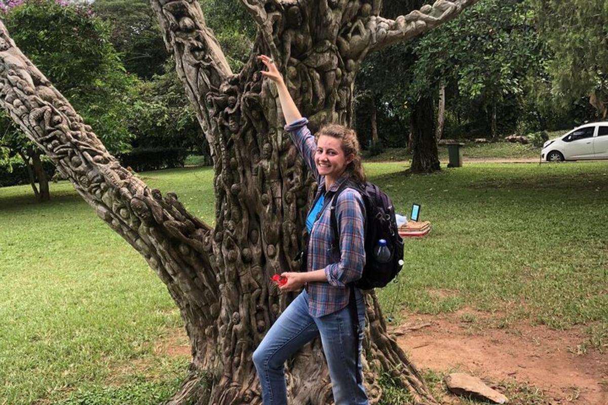 una donna è in piedi accanto a un albero
