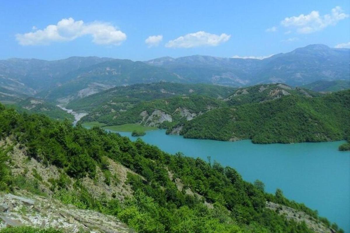 Una vista de un valle de montaña con un lago azul.