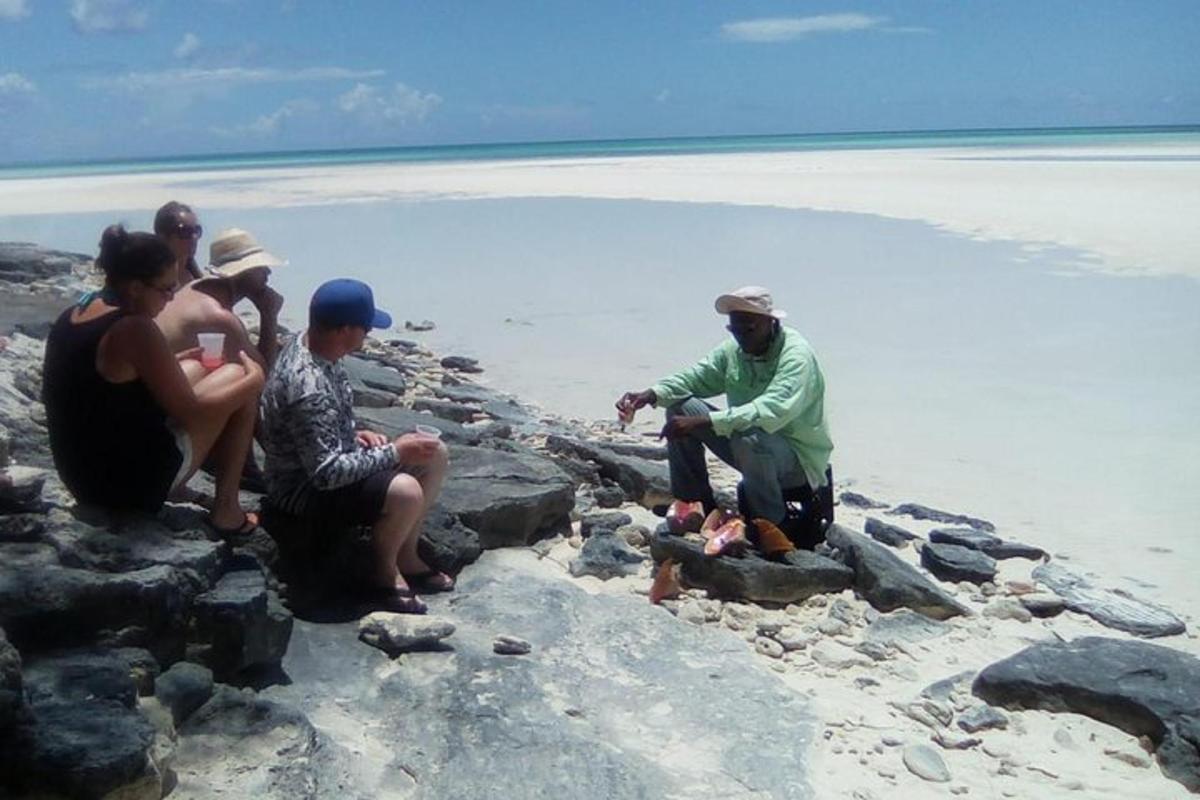 a group of people sitting on rocks on the beach