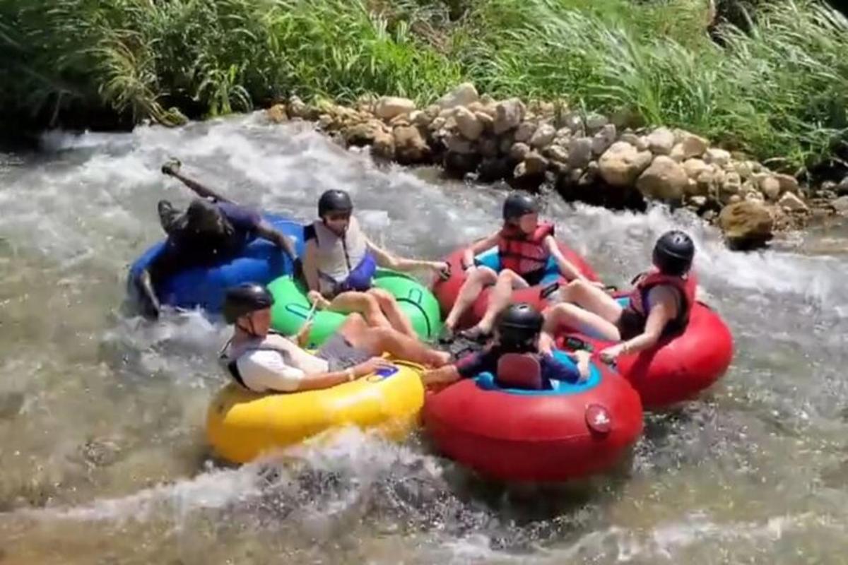 skupina lidí sjíždějících řeku na raftech
