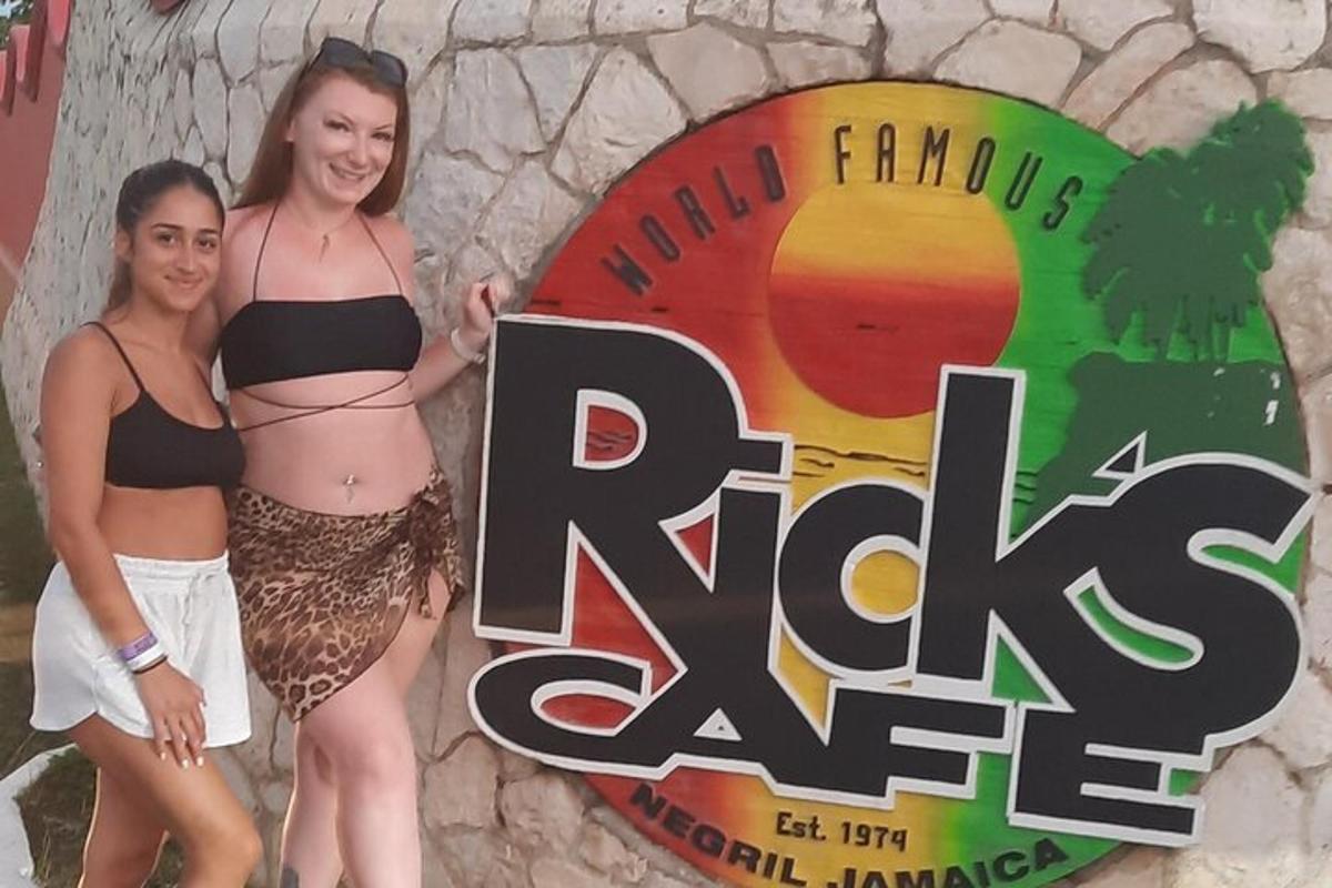 zwei Frauen in Bikinis stehen vor einem Schild