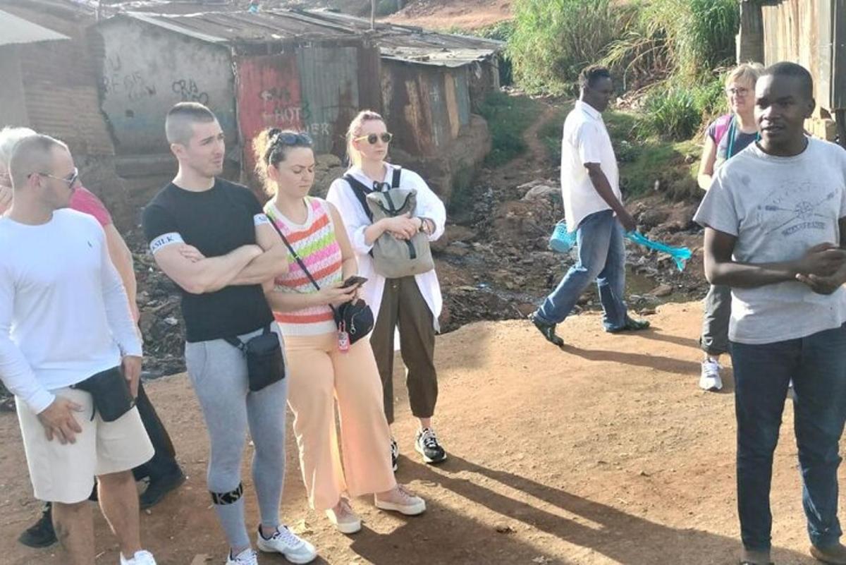 un gruppo di persone in piedi in un campo sterrato