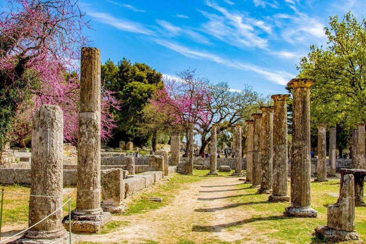 uma fileira de colunas em um parque com árvores