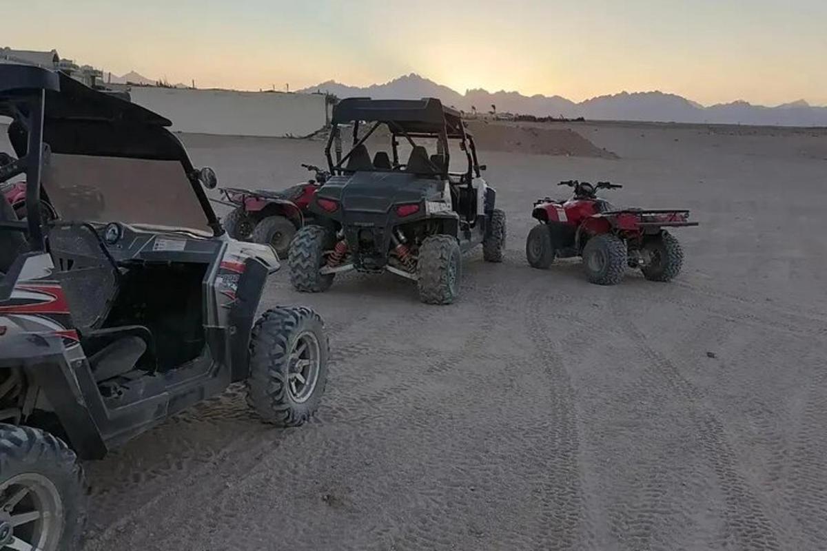 a group of four atvs and a jeep in the desert
