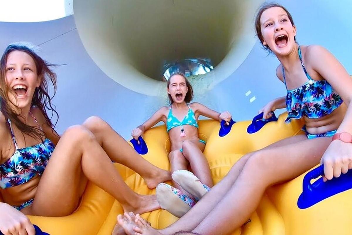 three young girls in bathing suits sitting on an inflatable