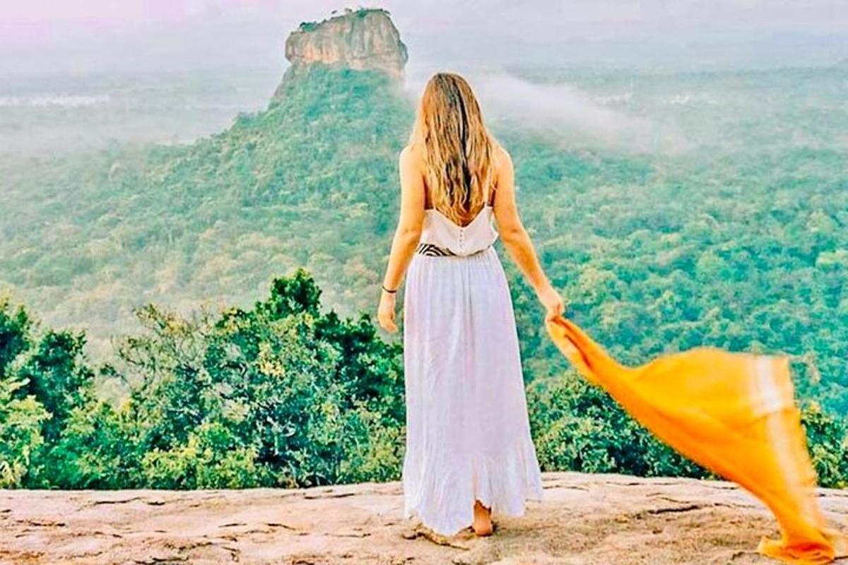 امرأة ترتدي ثوبًا أبيض تقف على قمة جبل