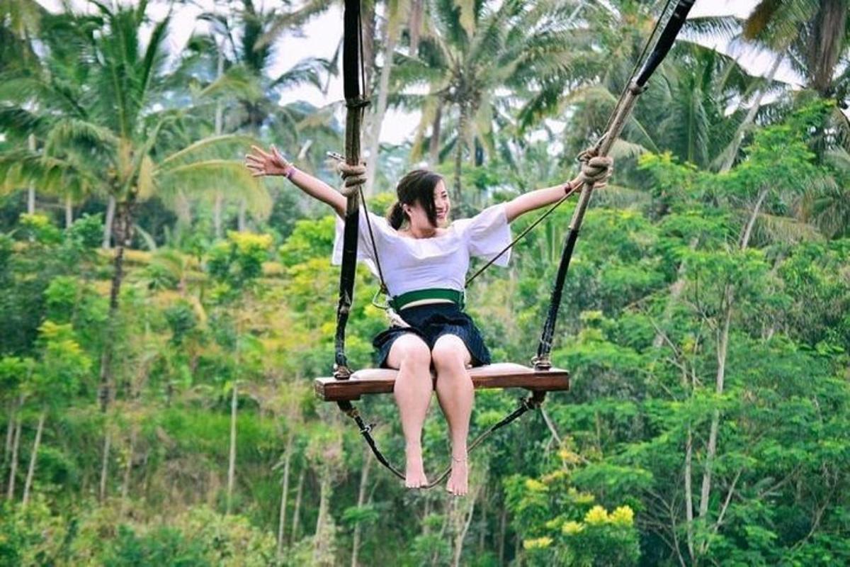 una dona asseguda en un gronxador a la selva