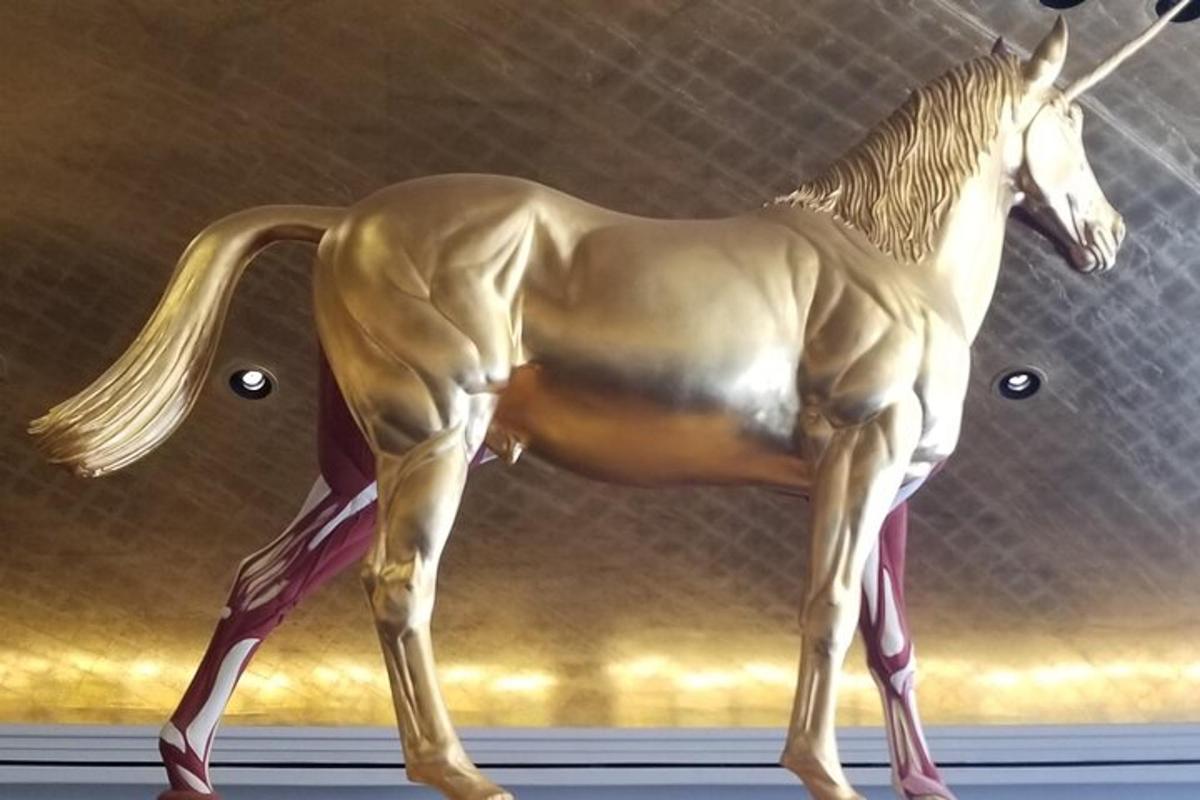 Una estatua de un caballo de pie sobre un estante.