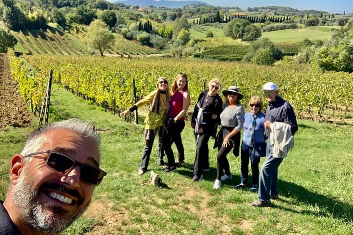 un grup de persones dretes davant d'una vinya