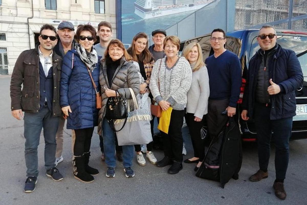 un grup de persones dretes davant d'un autobús