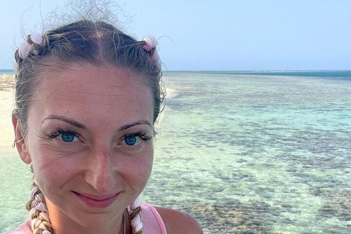 水辺の近くの浜辺に立っている女性