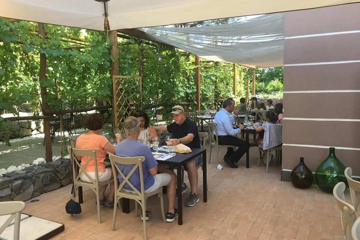 un grup de persones assegudes a una taula sota un paraigua