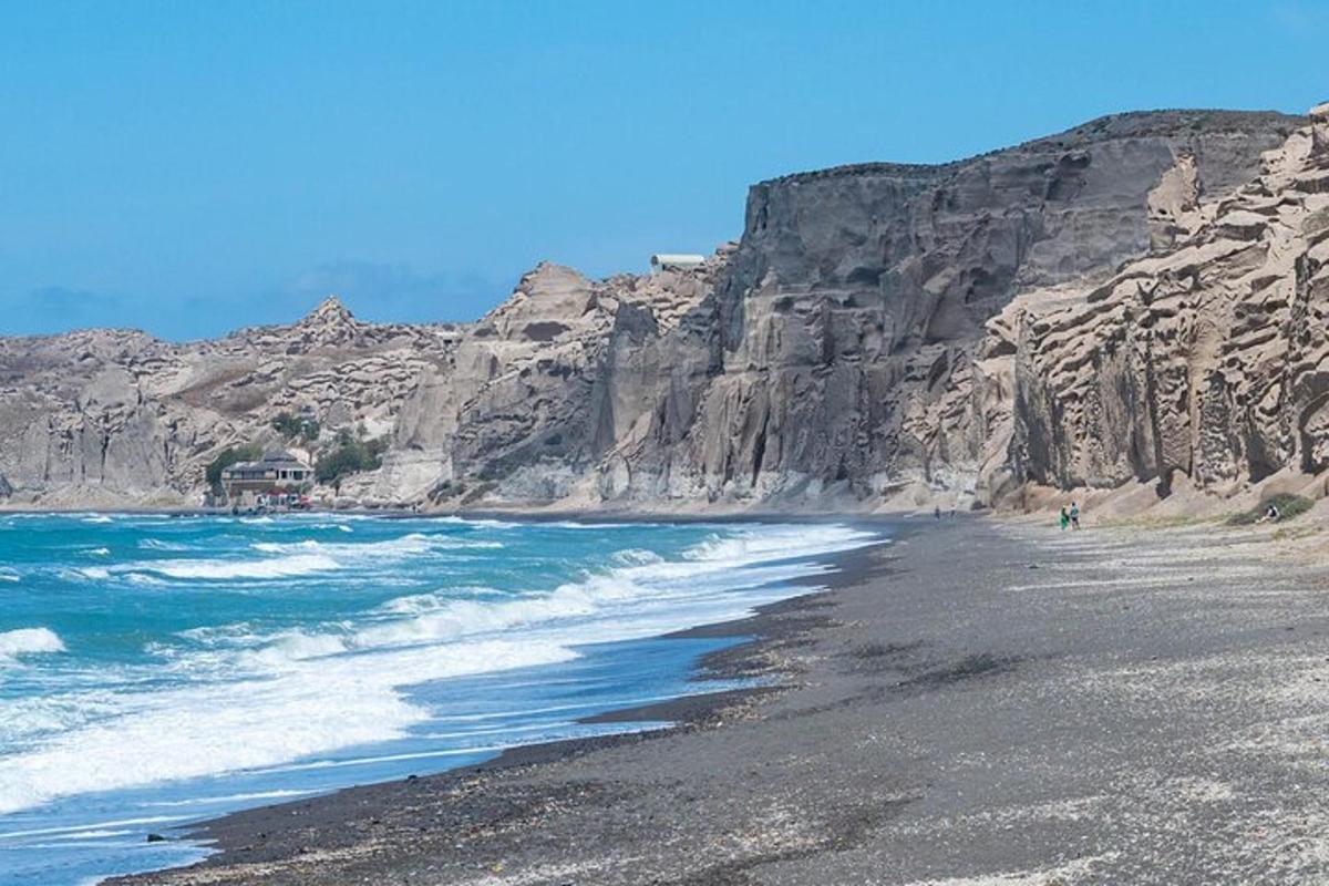 pantai hitam dengan gunung berbatu di latar belakang