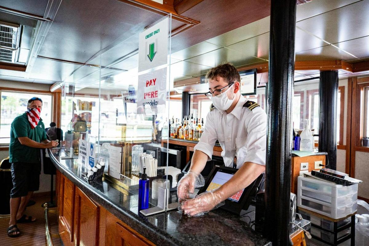 a man wearing a face mask standing at a counter