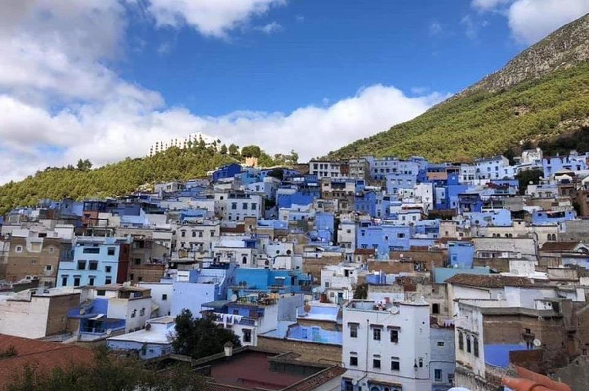 sebuah bandar dengan bangunan biru dan putih di atas bukit