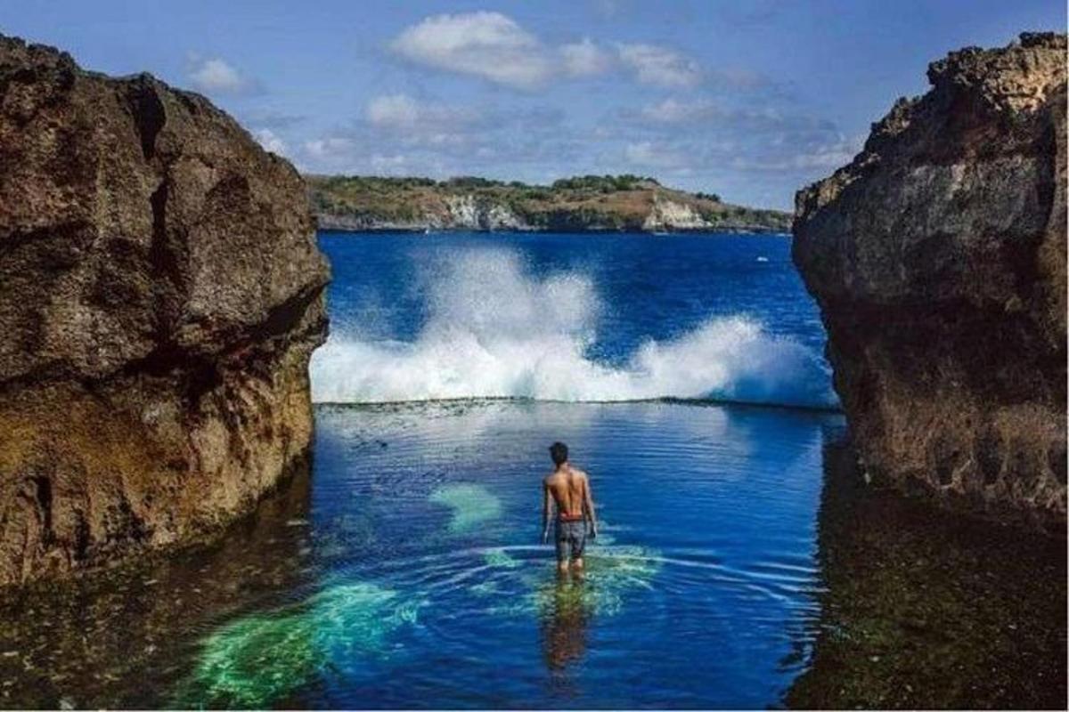 一名男子站在海浪前的水中