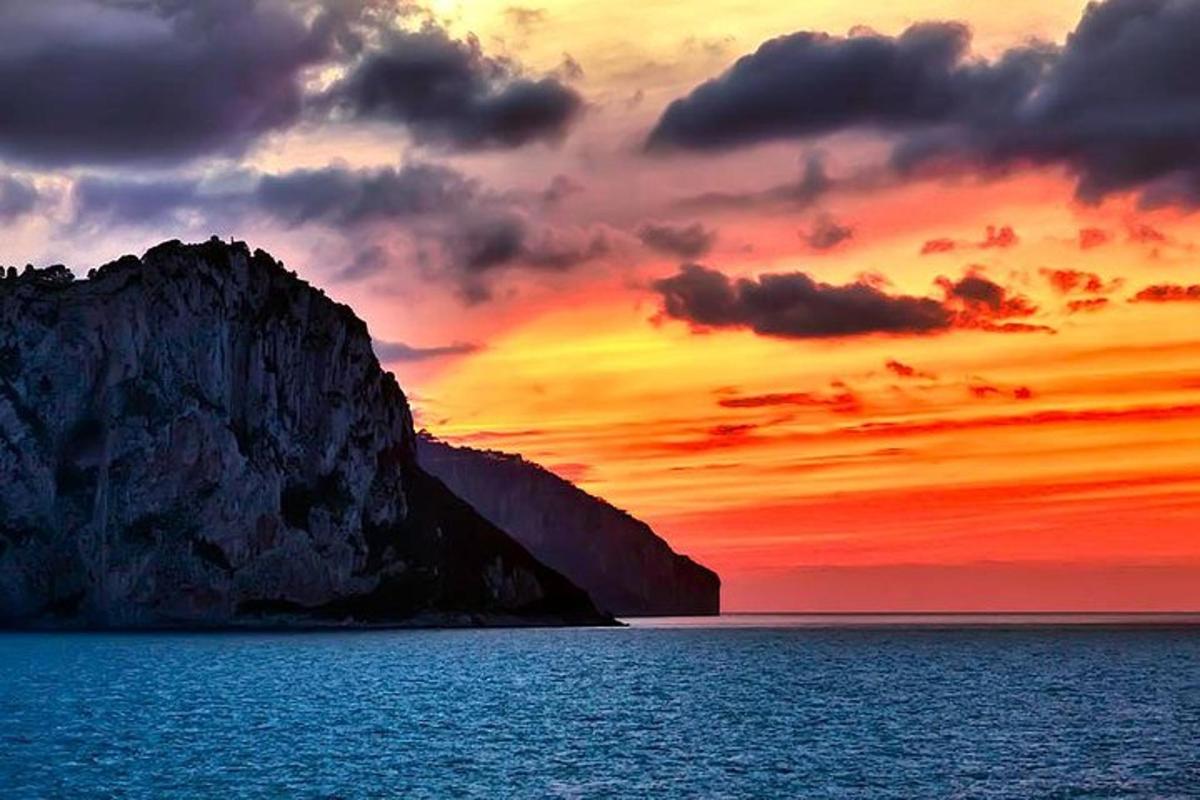 Západ slunce nad oceánem s velkou horou