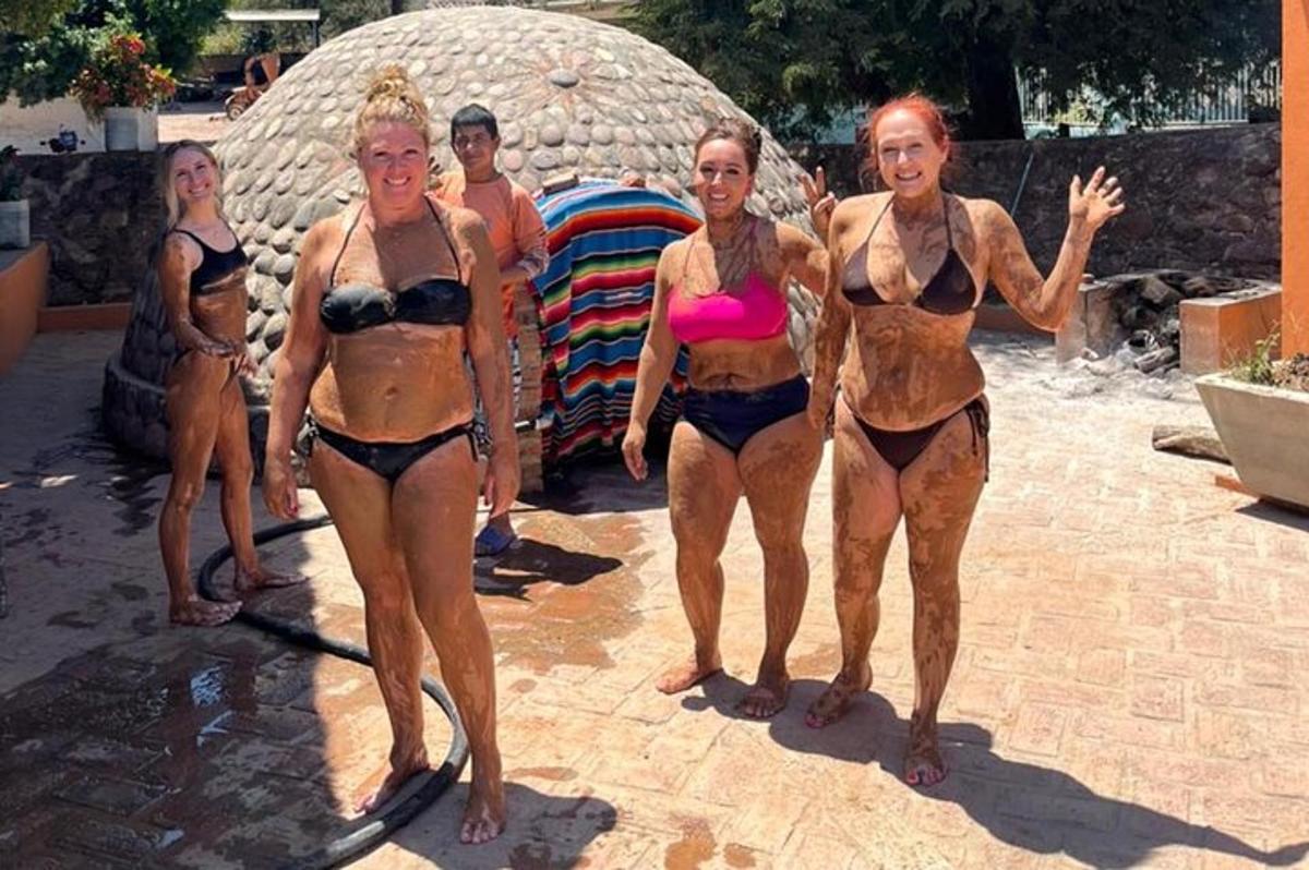 a group of women in bathing suits standing in the water