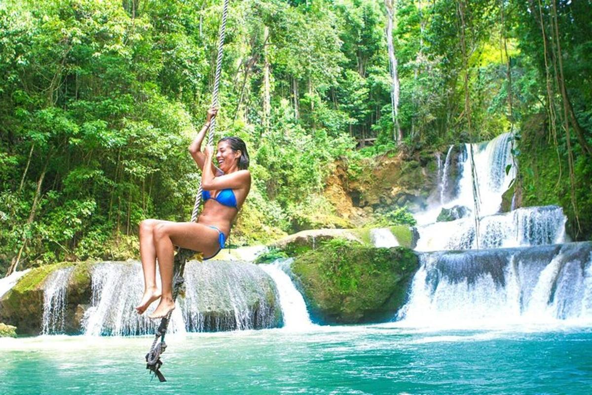 kobieta w bikini skacząca do wodospadu