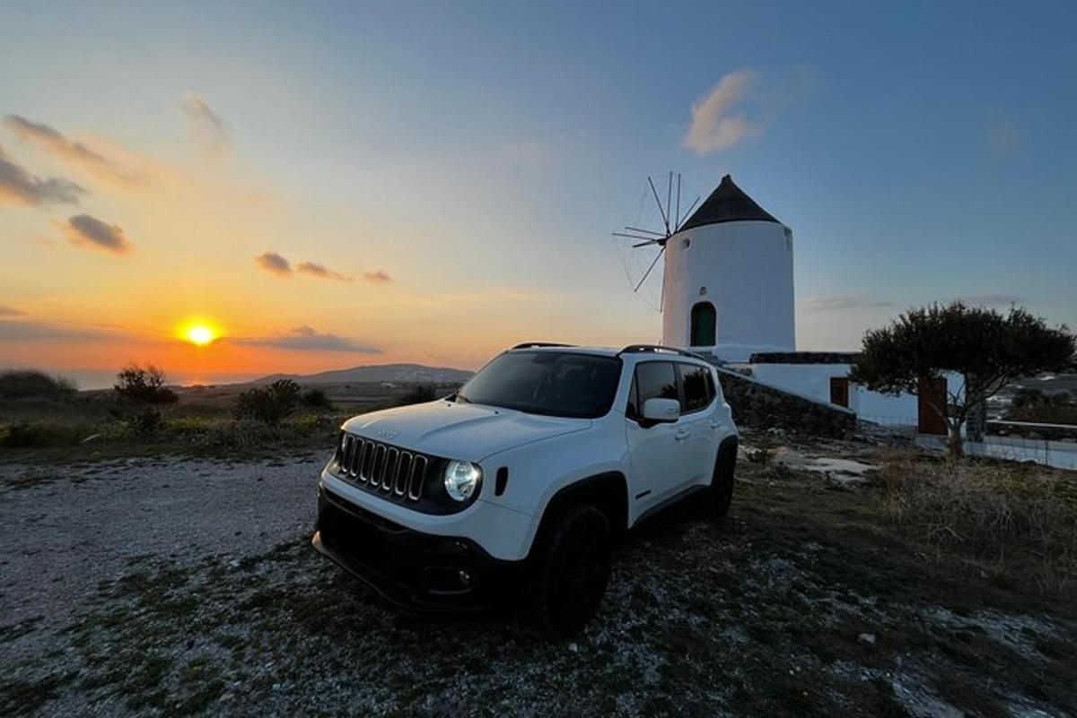 un jeep blanc aparcat davant d'un molí de vent