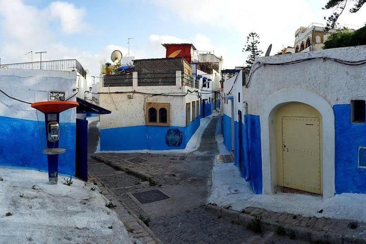um beco com prédios azuis e brancos e um parquímetro