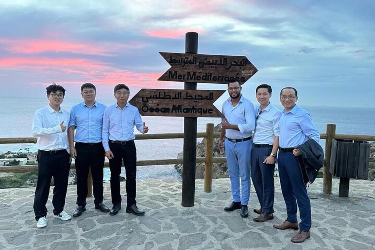 a group of men standing in front of a sign