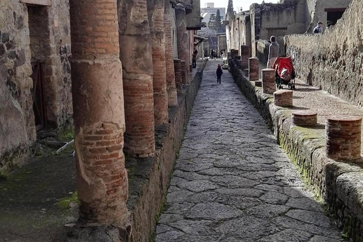un vicolo con colonne e una persona che cammina lungo una strada