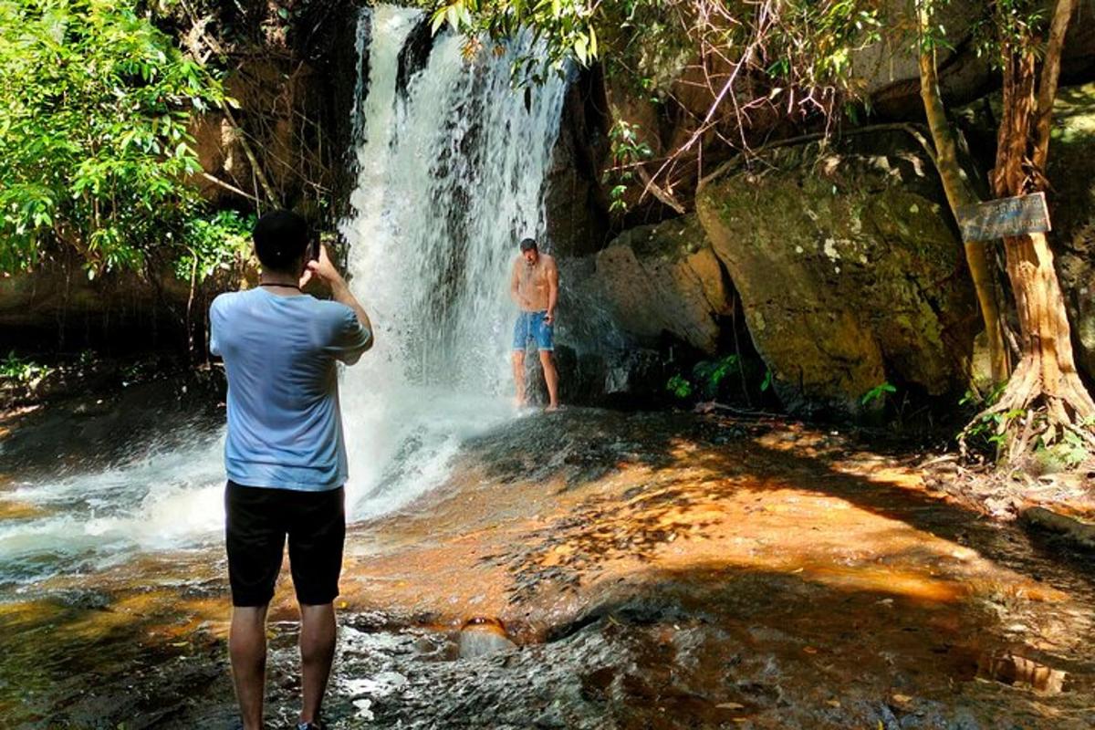un uomo che scatta una foto di una cascata