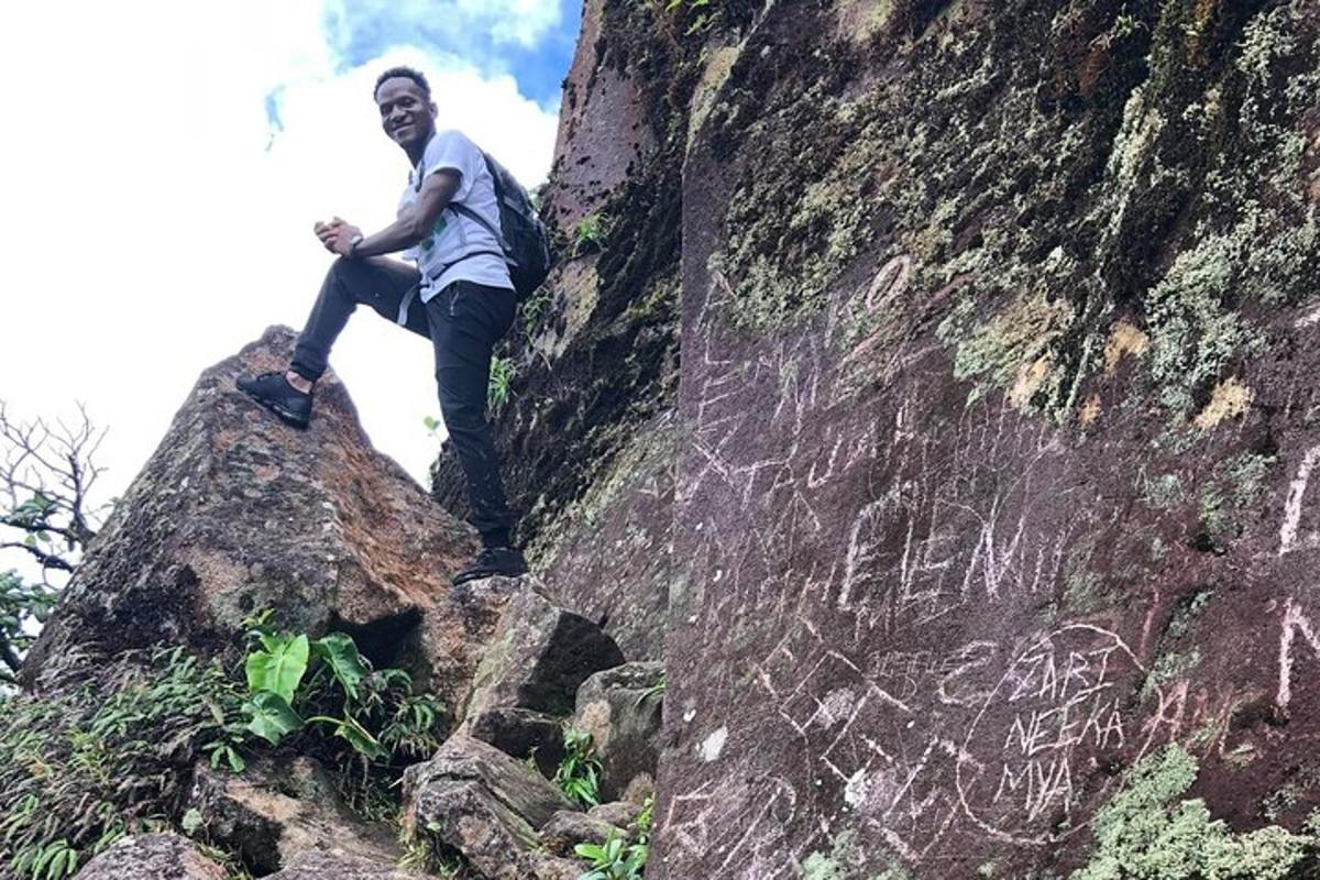 a man sitting on the side of a rock
