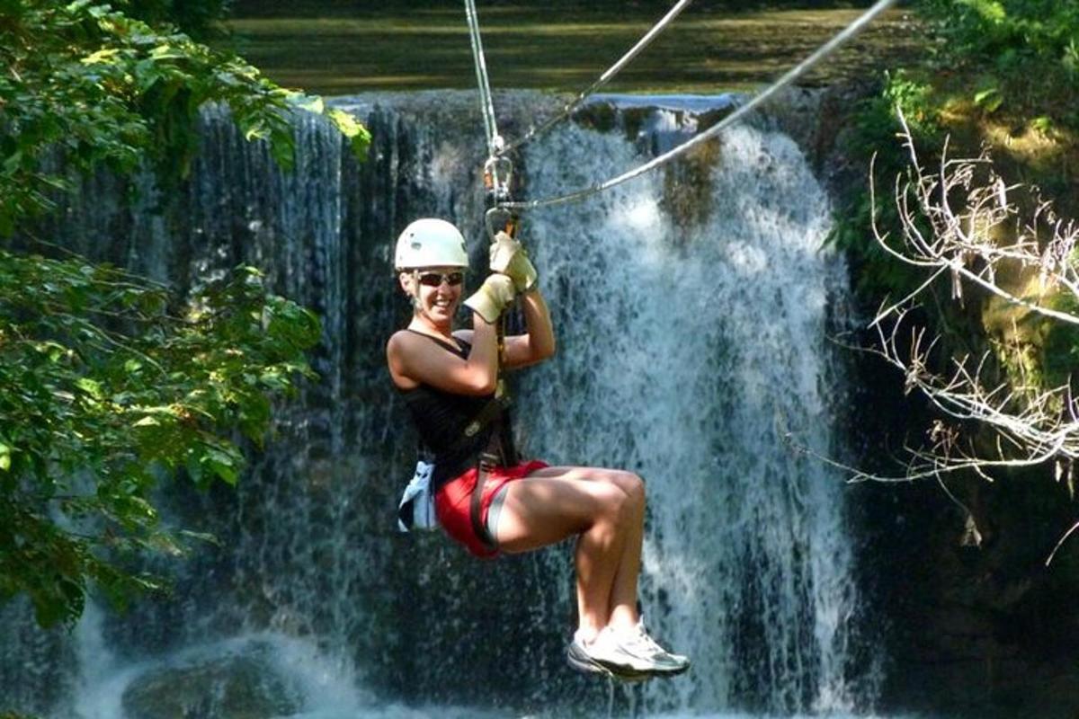 una mujer en una tirolina sobre una cascada