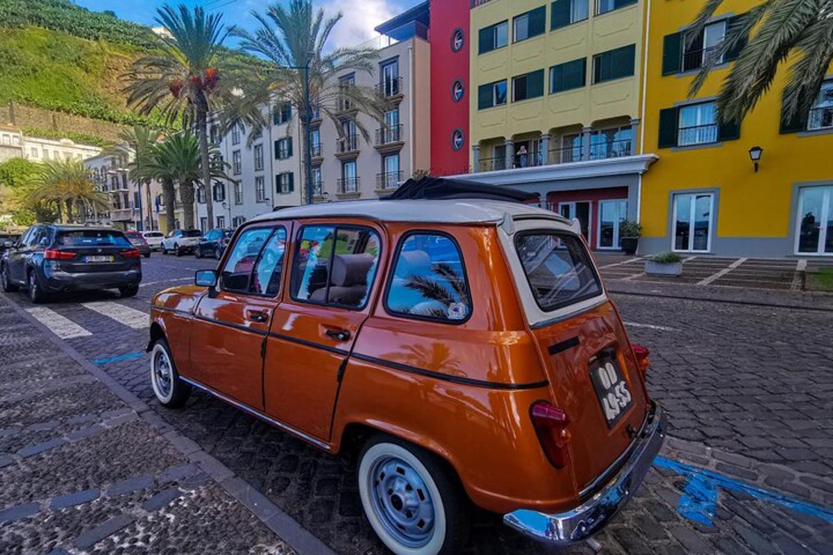 una piccola auto arancione parcheggiata su una strada cittadina