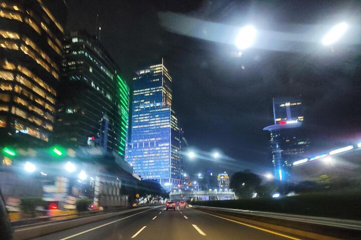 uma rua da cidade à noite com prédios altos