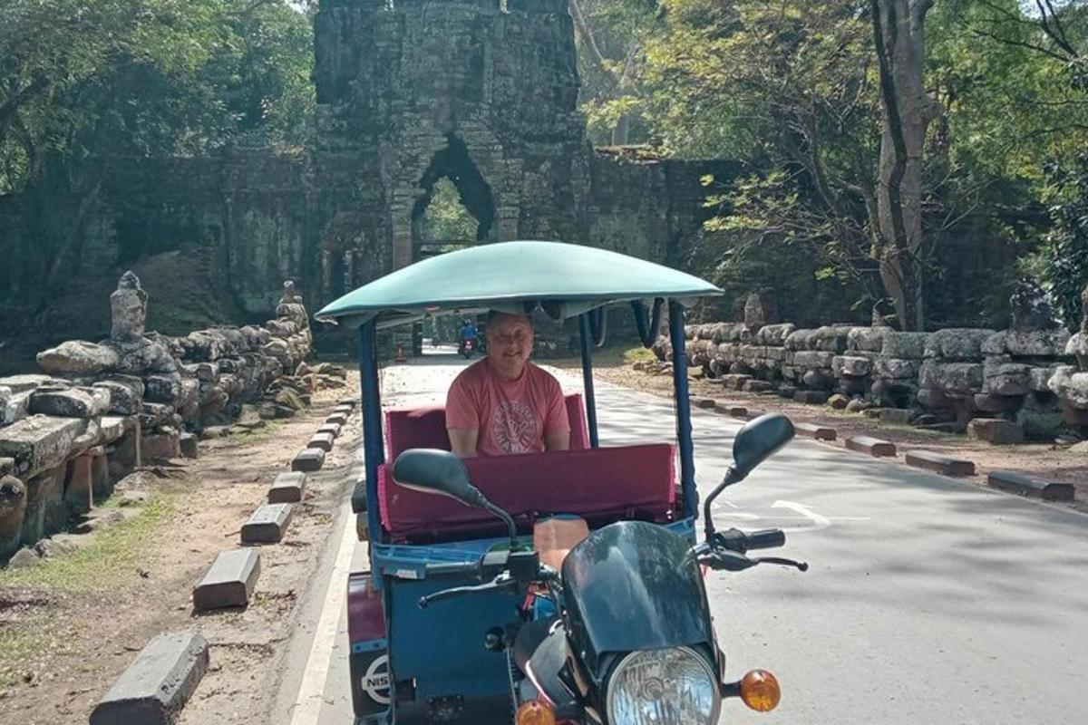 un uomo alla guida di un golf cart lungo una strada