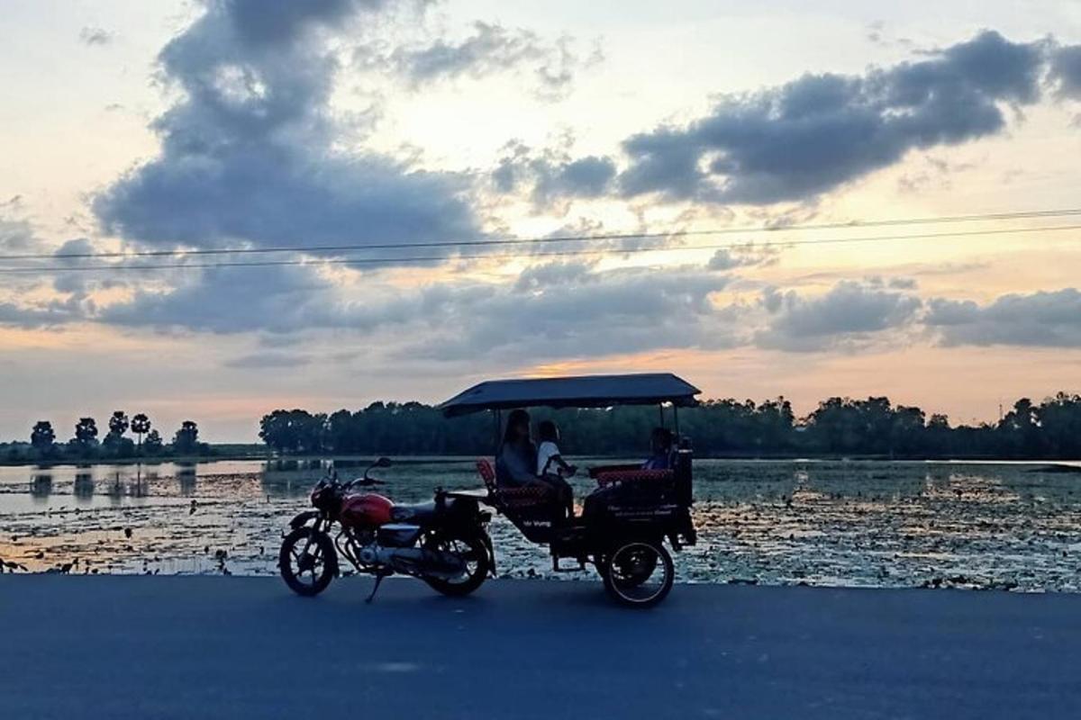 Una motocicleta y un carrito de golf estacionados junto a un cuerpo de agua