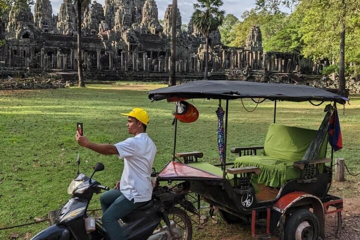 een man die in een golfkarretje voor een tempel rijdt