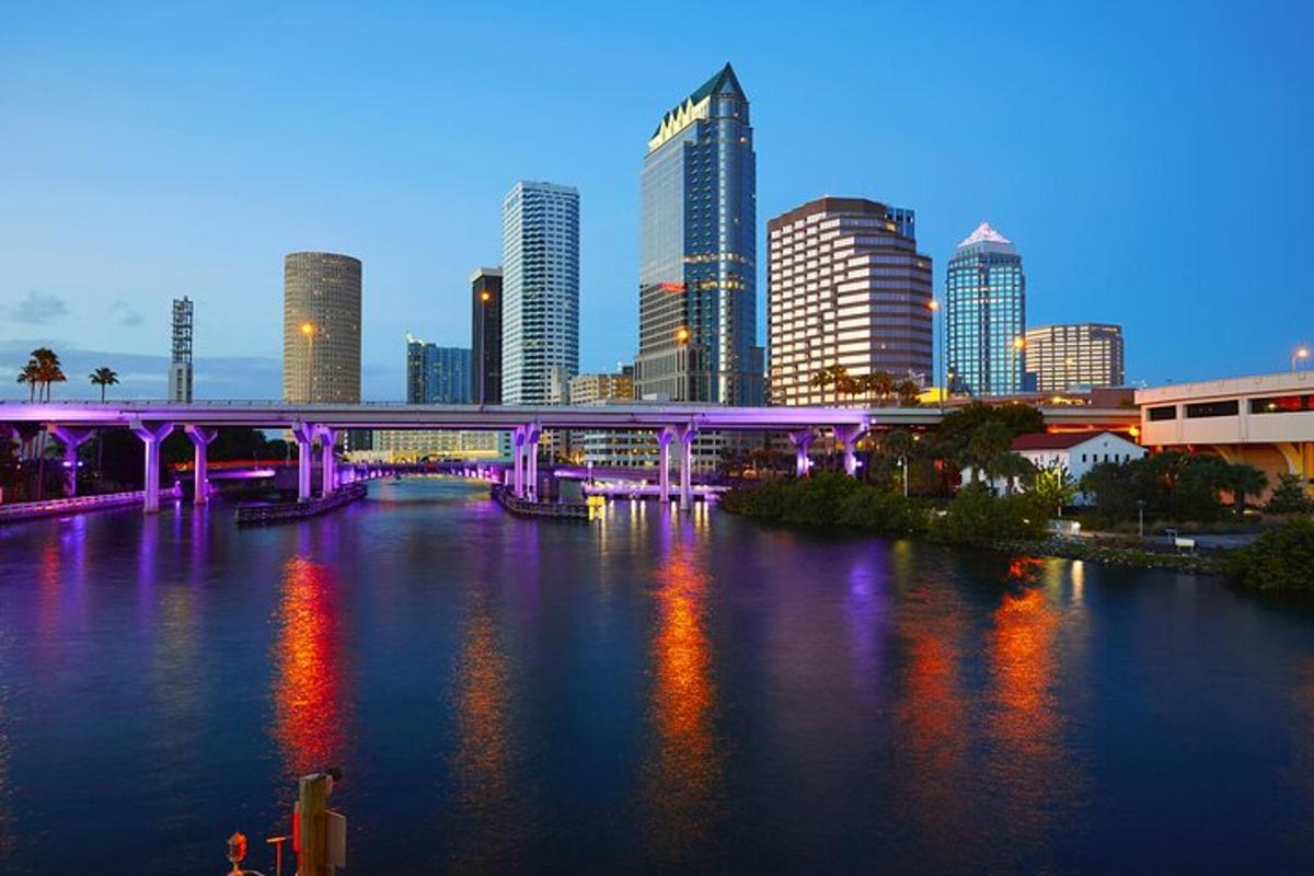 a purple bridge over a river in a city