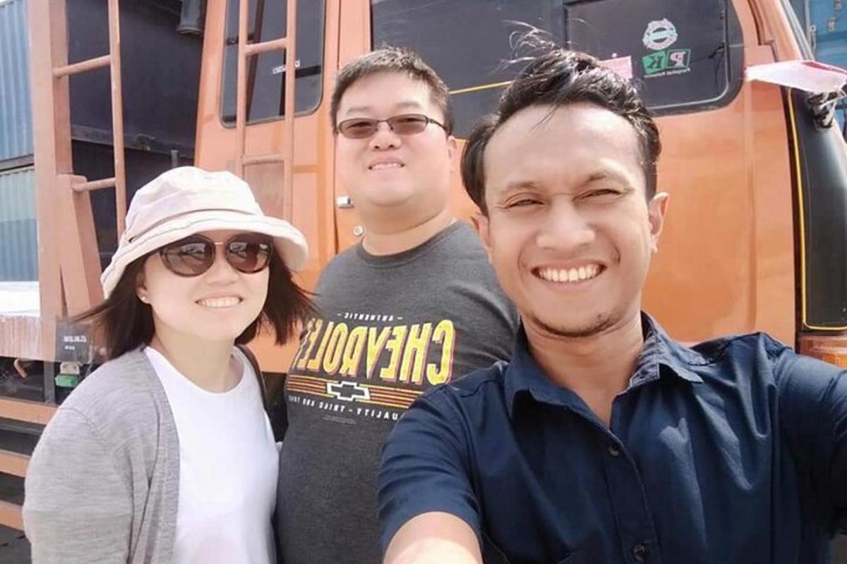 sekumpulan tiga orang berdiri di hadapan kereta api