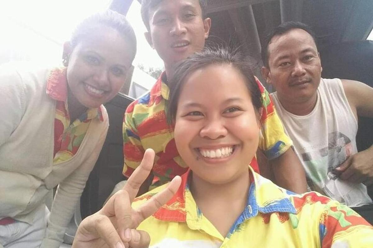 a group of people standing around a woman giving the peace sign