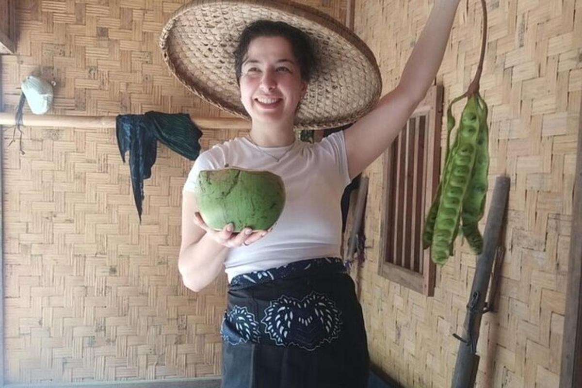 una donna con un cappello che tiene in mano un oggetto verde