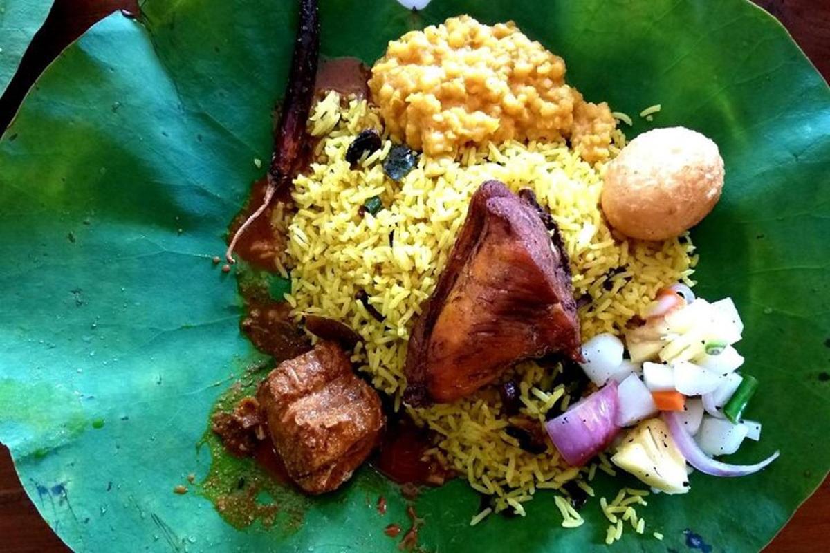 a plate of food with meat and rice on a leaf