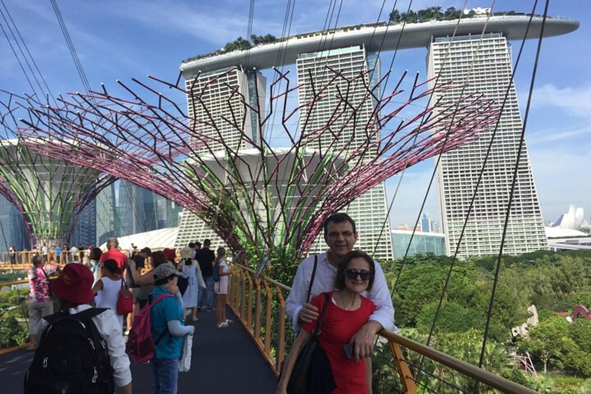 un uomo e una donna in piedi su un ponte con edifici sullo sfondo