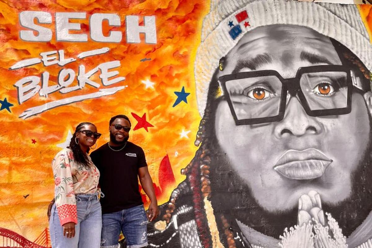a man and a woman standing in front of a mural